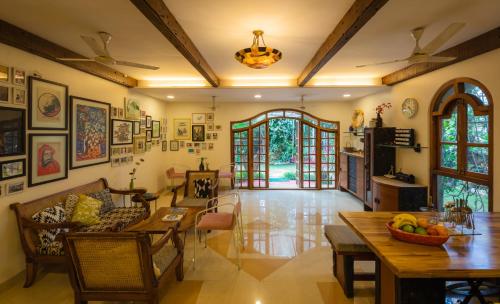 una sala de estar con una mesa y sillas en SaffronStays Birdsong, Madh - pet-friendly villa at Madh Island, en Bombay