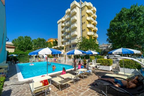 un hotel con piscina con sedie e ombrelloni di Hotel Oceanic a Rimini