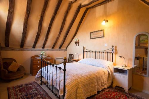 1 dormitorio con 1 cama y 1 silla en The Old Monkey, a quirky bolthole on the edge of a historic Market Town en Hadleigh
