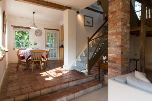 a living room with a staircase and a table and chairs at The Old Steam Mill, luxury, spacious, beautiful grounds, stunning location in Hartest