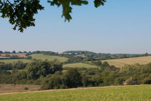 a view of a field with trees and hills at The Old Steam Mill, luxury, spacious, beautiful grounds, stunning location in Hartest