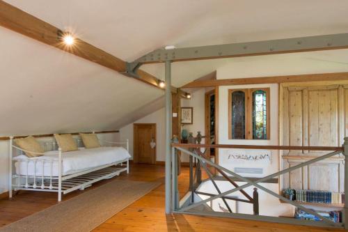 a bedroom with a white bed in a attic at The Old Steam Mill, luxury, spacious, beautiful grounds, stunning location in Hartest