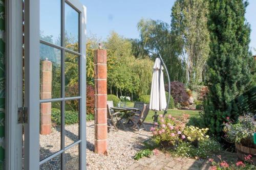 a view of a garden through an open window at The Old Steam Mill, luxury, spacious, beautiful grounds, stunning location in Hartest