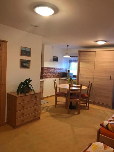 a living room with a table and chairs and a kitchen at Pod Smrcinou in Nová Pec
