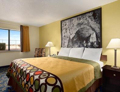 a hotel room with a large bed and a window at Super 8 by Wyndham Carlsbad in Carlsbad