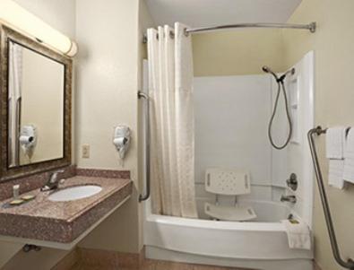 a bathroom with a sink and a shower with a mirror at Super 8 by Wyndham Carlsbad in Carlsbad