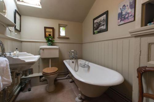 a bathroom with a tub and a toilet and a sink at Cissys Cottage in a Nature Reserve, 7 minutes from Aldeburgh seafront 