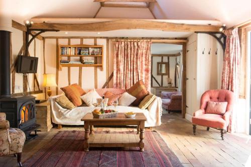 a living room with a couch and a fireplace at Bromans Barn a beautiful cottage by the Sea and Cudmore Nature Reserve in West Mersea