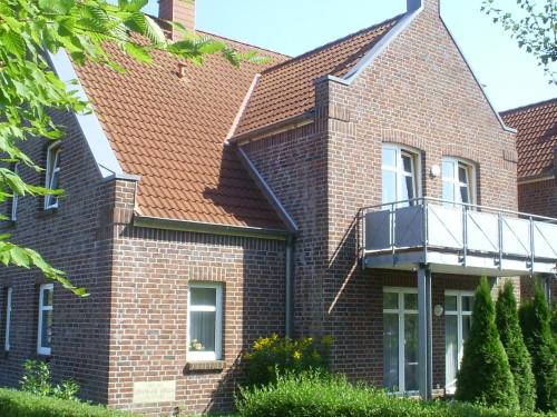 a brick house with a balcony on it at Ferienwohnung Wattwurm Dangast in Varel