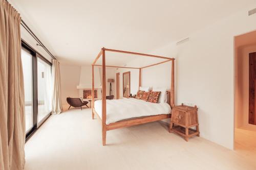 Fully Staffed Sea Front Villa with Private Sommelier في مورايرا: غرفة نوم مع سرير مظلة مع مرآة