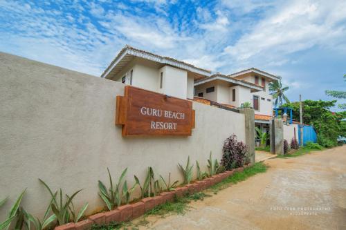 a sign on the side of a building at Guru Beach Resort in Tangalle