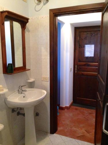 a bathroom with a sink and a mirror and a door at agriturismo u zu peppino in Lipari