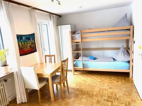 a small room with a bunk bed and a table at Gemütliche Privatzimmer mit geteiltem Bad, Küche und Garten in Munich