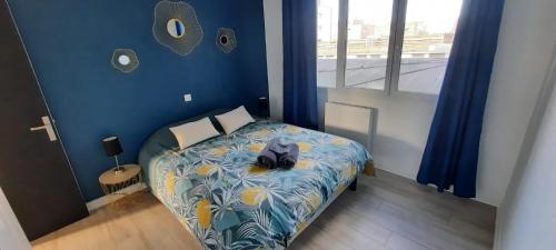 a bedroom with a bed with a cat sitting on it at Appartement Entre terre et mer in Dunkerque