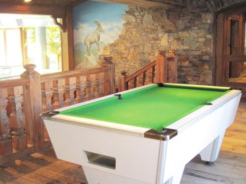 a pool table in a room with a stone wall at Happy Moose - Cosy Mont Blanc View apartment in Chamonix-Mont-Blanc