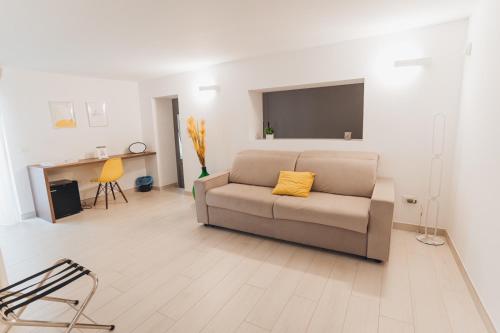 a living room with a couch with a yellow pillow at A-mare Exclusive Rooms & Suites in Taranto