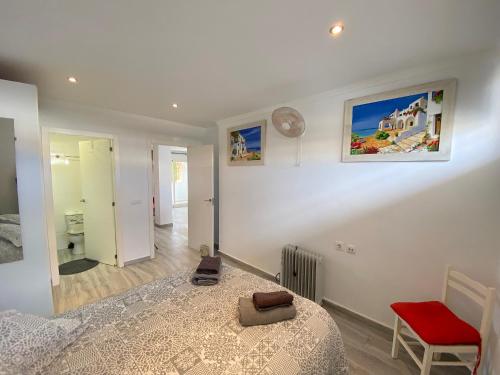 a bedroom with a bed and a red chair at Blue Moon Apartment in Puerto de Mazarrón