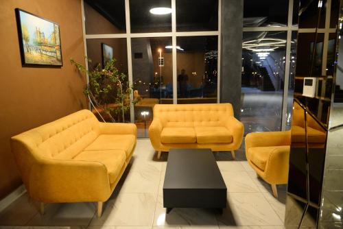a waiting room with two yellow couches and a table at Verdisso Hotel & Restaurant in Demir Kapija