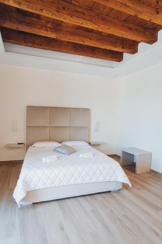 a white bedroom with a bed and a wooden ceiling at A-mare Exclusive Rooms & Suites in Taranto