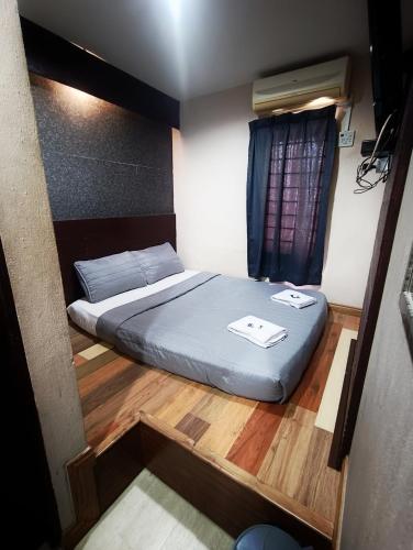 a small bedroom with a bed and a window at Hotel Musfa in Kota Bharu