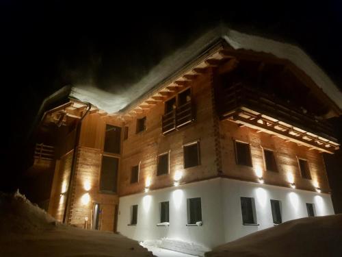 a building is lit up at night in the snow at Landhaus Wiesle in Tannheim
