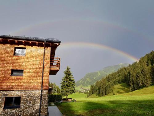 a rainbow is in the sky behind a building at Landhaus Wiesle in Tannheim