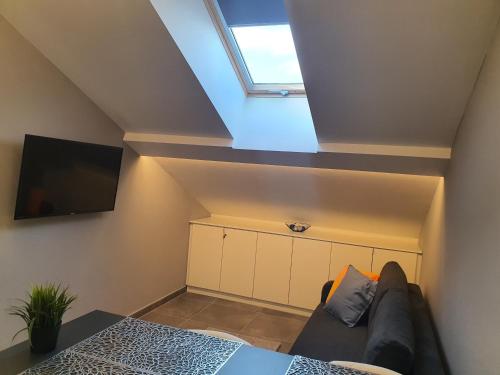 a living room with a couch and a skylight at Kaposvár Apartman in Kaposvár