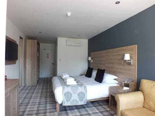 a hotel room with a bed and a chair at The Piebald Inn in Hunmanby