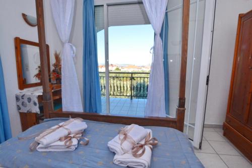 a bedroom with a bed with a view of a balcony at Effi's Garden Villa in Limenas