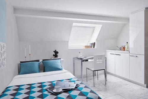 Schlafzimmer mit einem Bett mit blauen Kissen und einem Tisch in der Unterkunft VISIONAPARTMENTS Binzmühlestrasse 46 - contactless check-in in Zürich