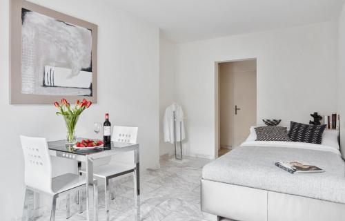 ein weißes Schlafzimmer mit einem Bett, einem Tisch und Stühlen in der Unterkunft VISIONAPARTMENTS Binzmühlestrasse 46 - contactless check-in in Zürich