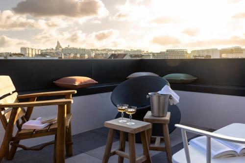 a balcony with two chairs and a table with wine glasses at MOB House in Saint-Ouen