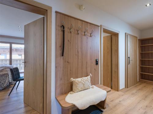 a room with a wooden wall with a chair in it at Isskogel Suites in Gerlos