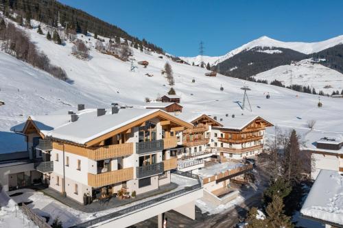 a ski lodge in the snow with a ski slope at Isskogel Suites in Gerlos