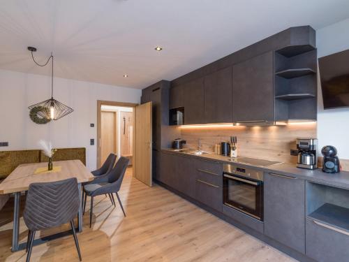 a kitchen with a table and a dining room at Isskogel Suites in Gerlos