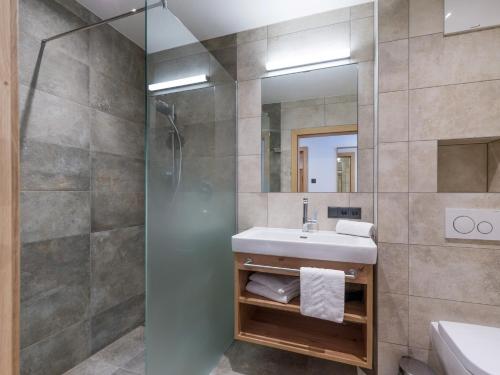 a bathroom with a sink and a shower at Isskogel Suites in Gerlos