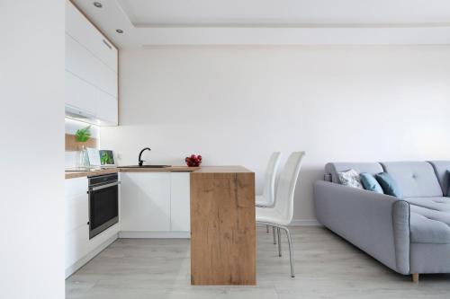 a kitchen and living room with a couch and a table at Elite Apartments Sunny in Gdańsk