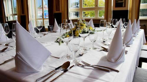 a long table with white napkins and silverware on it at Hotel Pestalozzi Lugano in Lugano