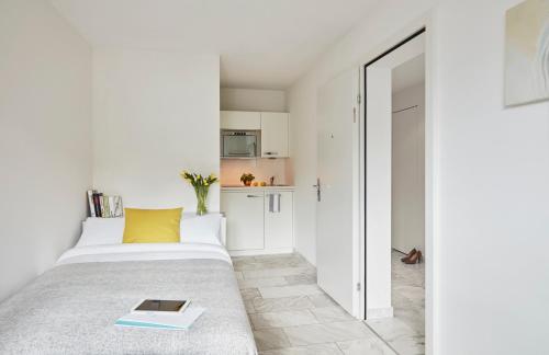 a bedroom with a bed with a book on it at VISIONAPARTMENTS Binzmühlestrasse 46 - contactless check-in in Zürich