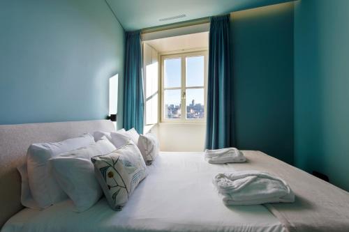 a blue bedroom with a bed with towels on it at BOUTIQUE Rentals-Kinga’s Ribeira River great views in Porto