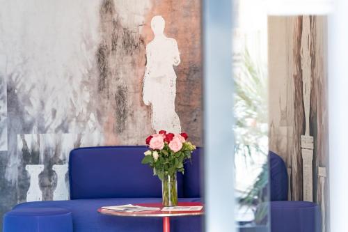 a vase of flowers on a table in a room at Hotel Pestalozzi Lugano in Lugano