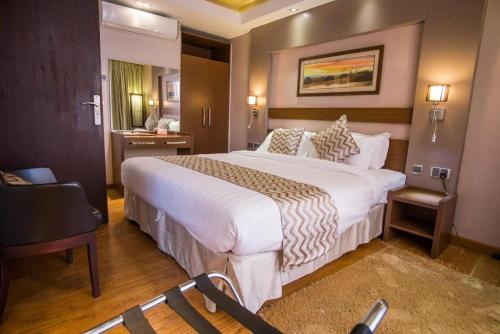 a hotel room with a large bed and a chair at Ngong Hills Hotel in Nairobi