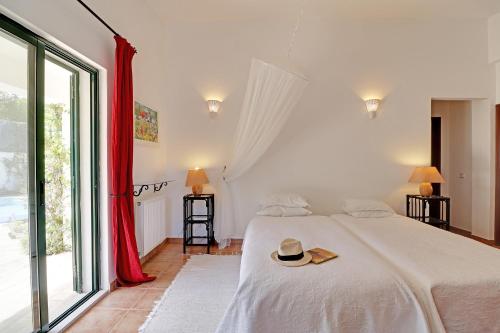 een slaapkamer met een bed met een hoed erop bij Algarve Country Villa With Pool by Homing in Santa Bárbara de Nexe