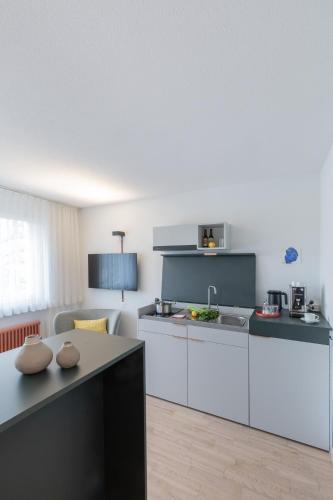 a kitchen with white cabinets and a table at Alpenblick Bern - kind of a hotel in Bern