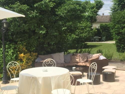 a table and chairs and a couch in a yard at Domaine du Manoir in Les Avenières
