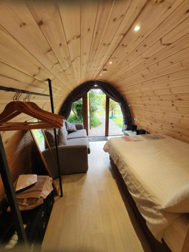 a bedroom with a bed and a couch in a room at Priory Glamping Pods and Guest accommodation in Killarney