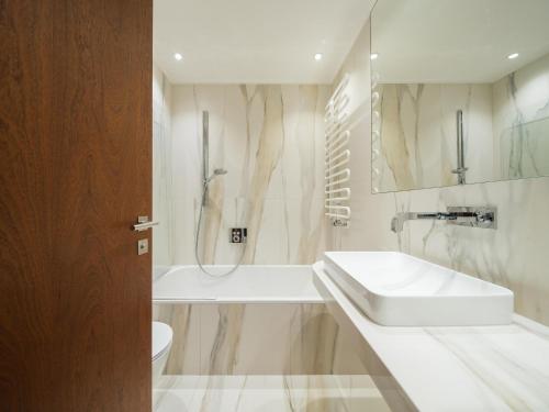 ein Badezimmer mit einem Waschbecken, einer Badewanne und einer Dusche in der Unterkunft Apartment Ronch in Selva