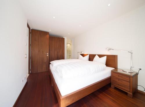 ein Schlafzimmer mit einem großen weißen Bett und einer Lampe in der Unterkunft Apartment Ronch in Selva