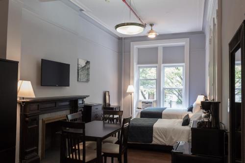 a hotel room with a bed and a desk and a table at The Central Park North in New York