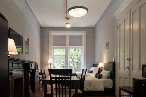 a room with a bed and a table and a window at The Central Park North in New York